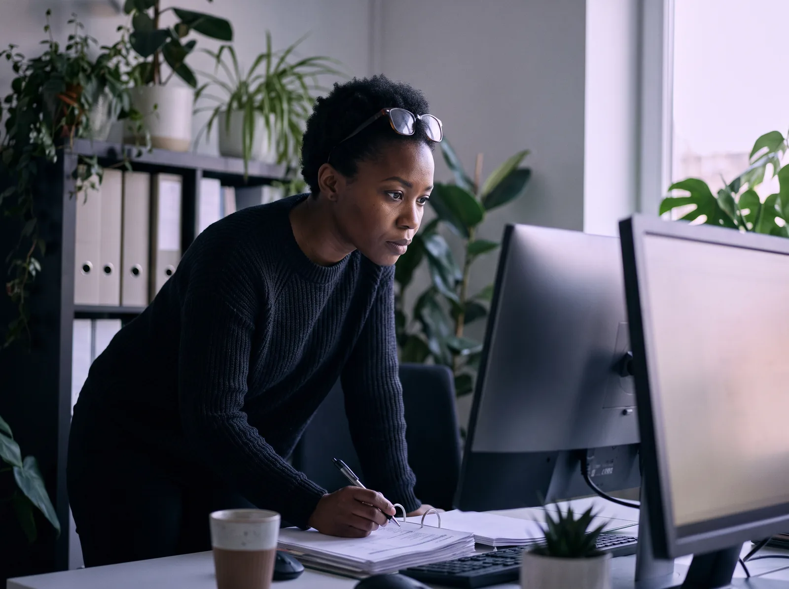 An accountant at her desk reviewing a client's books